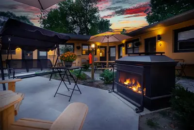 The courtyard at golden hour, firepit lit, cabins around