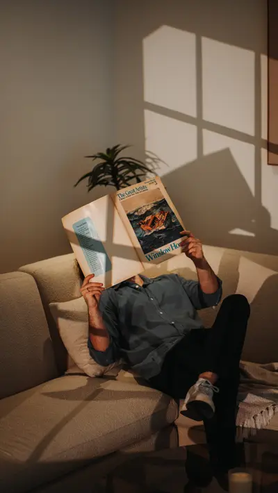 Reading on the bouclé sectional in window light.