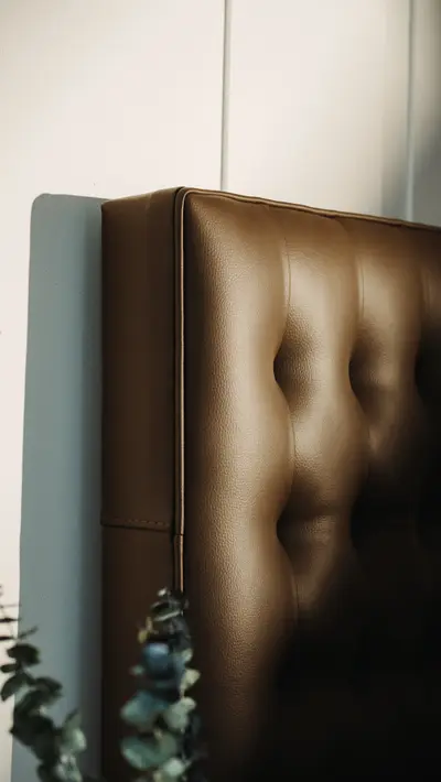 Tufted saddle leather headboard, eight-button hand-set.