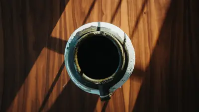Glazed vessel from above on a walnut sideboard.