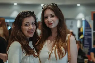 Two guests at the ConnecTR 2025 fair, posing for a portrait