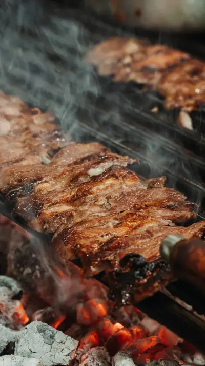 Skewers above coals, smoke rising in two registers