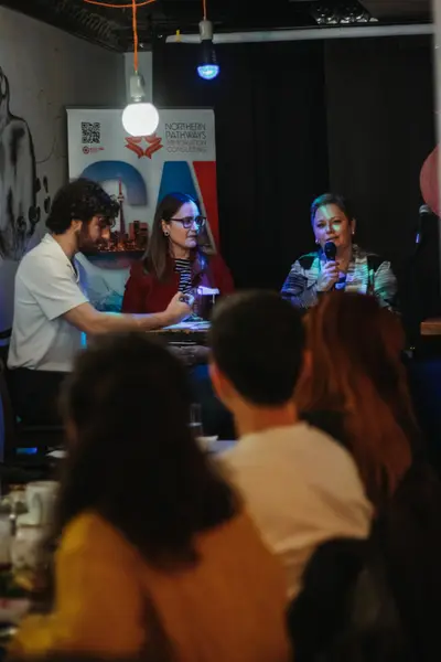 Guests at a table beside the event banner