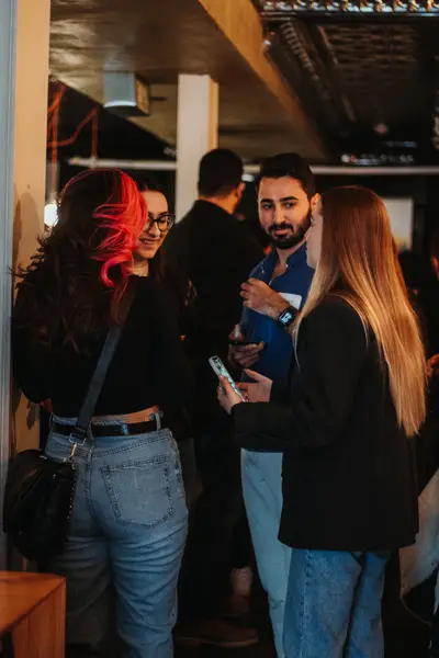 A group of guests talking, drinks in hand