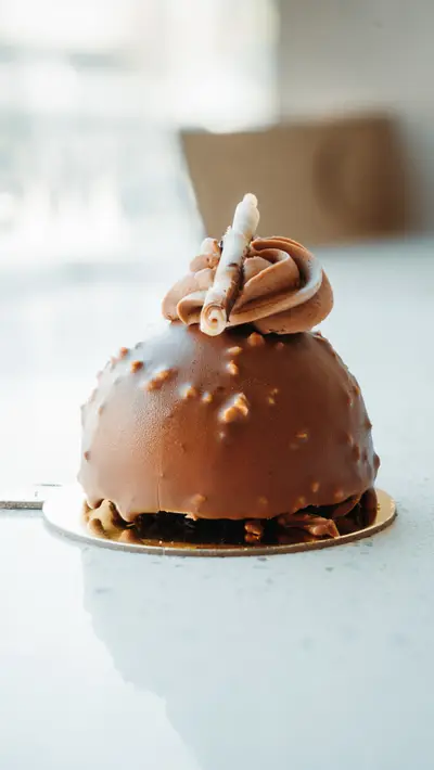 A chocolate dome finished with hazelnut crumb and a piped swirl
