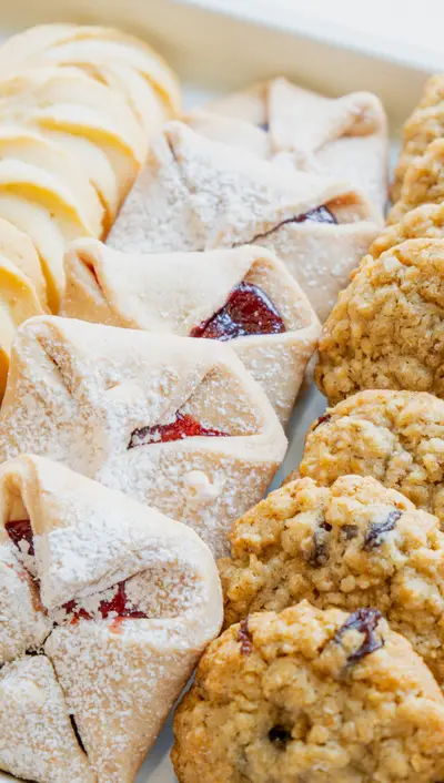 Powdered jam parcels beside oat cookies on a tray