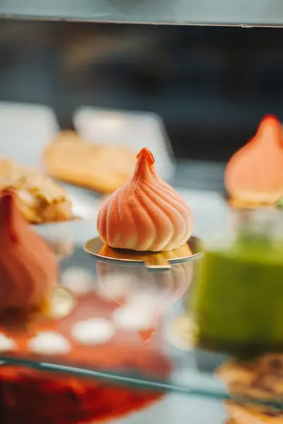 A meringue-peaked pastry among others in the display case