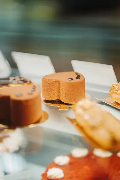 Glazed entremets lined up behind display glass