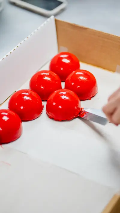 Red mirror-glazed domes arranged on a white tray
