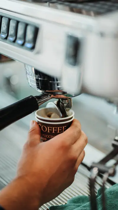 A takeaway cup filling under the espresso group head