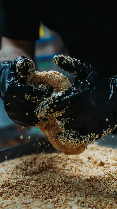 Crumb falling through gloved hands onto the bench
