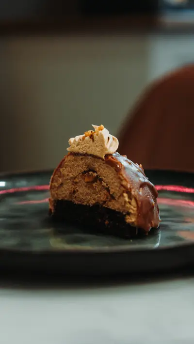 A praline dome cut open on a dark plate