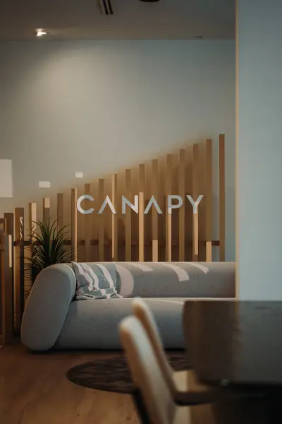A furniture showroom with a slatted timber screen and curved sofa