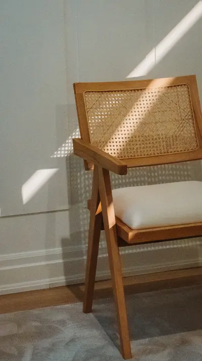 A cane chair standing in a shaft of window light