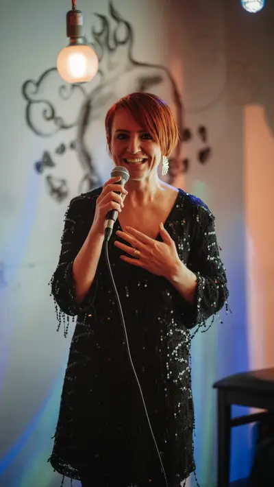 A singer in a sequinned jacket at the microphone