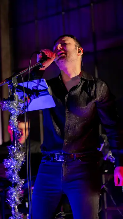A singer at the microphone lit blue from the side
