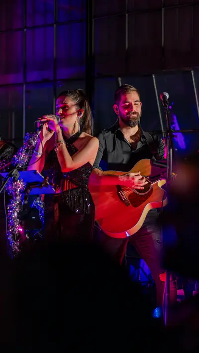 A singer and guitarist performing together on a small stage