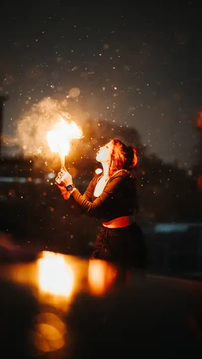 A fire breather with the spray catching light