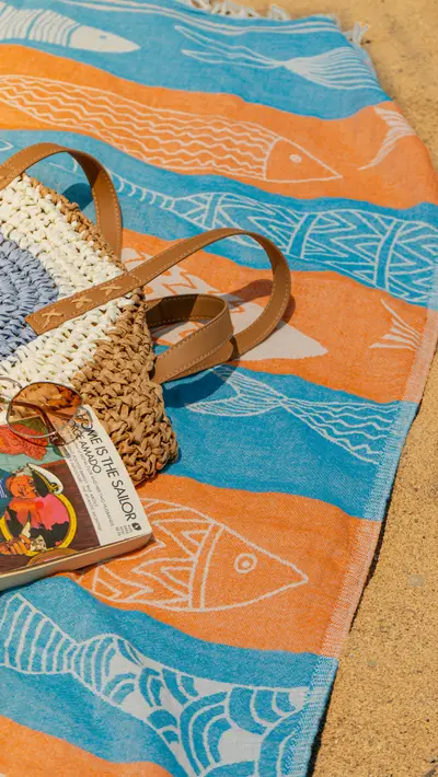 A woven bag on a towel with the product tag showing