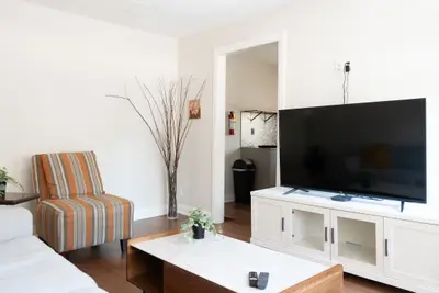A living room with a wall-mounted television and console