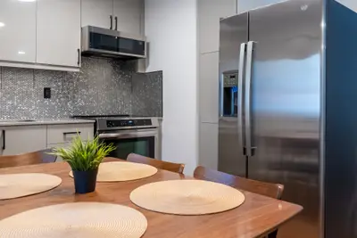 A set dining table with the stainless kitchen behind