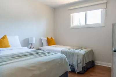 A bedroom with two queen beds and yellow cushions