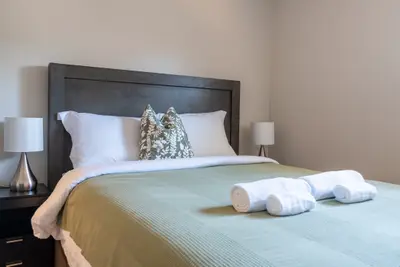 A king bed with a dark headboard and matching lamps
