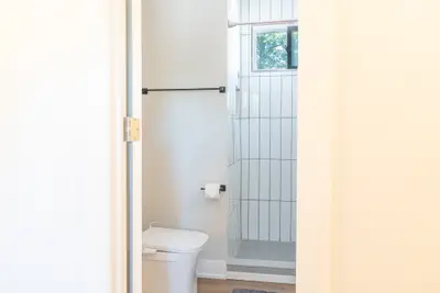 A tiled shower beside the toilet
