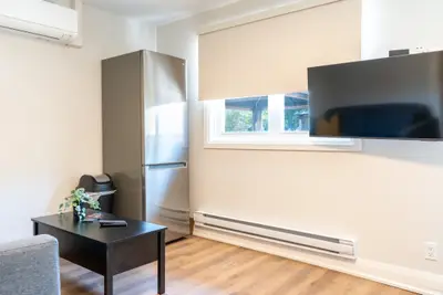 A studio unit with fridge, television and coffee table