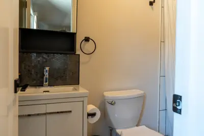 A vanity under a wall mirror with towel ring