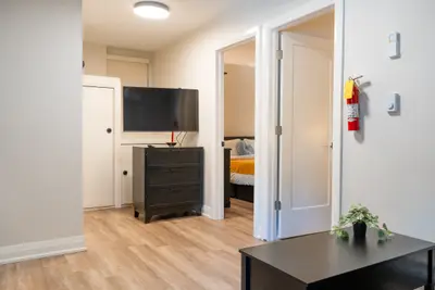 A hallway with television and the bedroom through the door