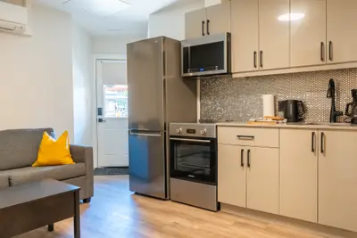 A sofa facing the open kitchen with stainless appliances