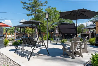 A swing seat and loungers on the courtyard gravel