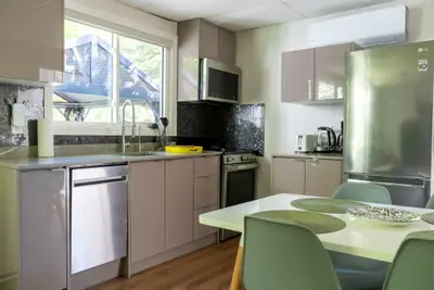 A kitchen with dishwasher, range and a set dining table