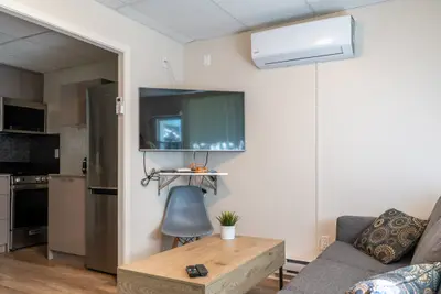A studio with wall television, sofa and coffee table