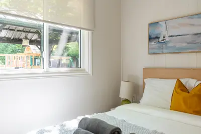 A bed beside an open window looking onto the grounds