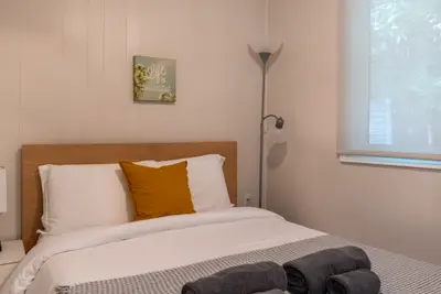 A bed with rolled towels and a standing lamp