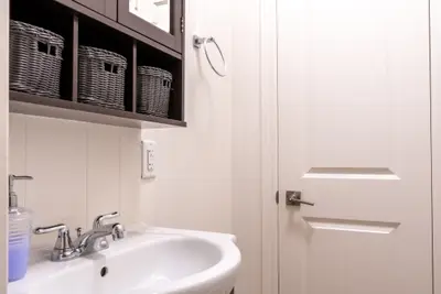 A basin with baskets on the shelf beside the door