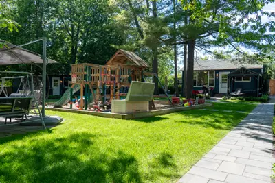 The lawn with playground equipment and cabins beyond