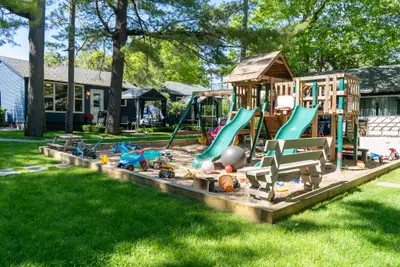 A wooden play structure with two green slides