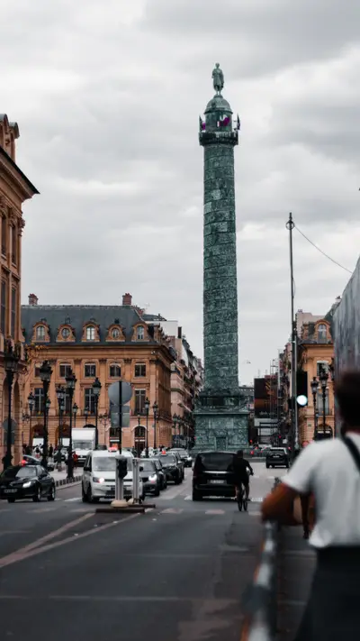 A bronze column rising above traffic in the square