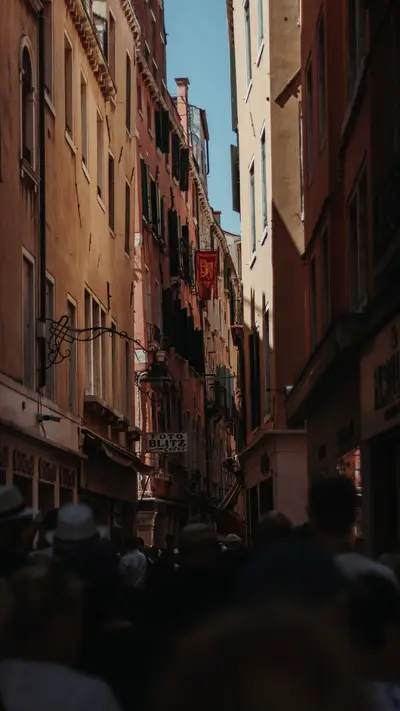 A Venetian street crowded between ochre walls
