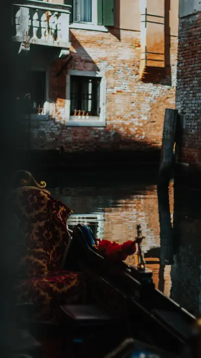 A gondola moored against a brick canal wall