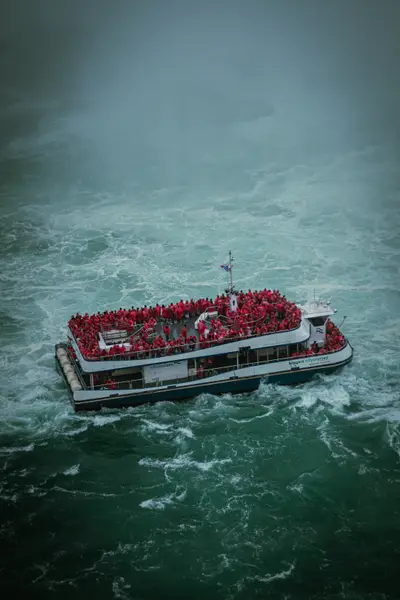 A tour boat crowded with passengers in the churning water